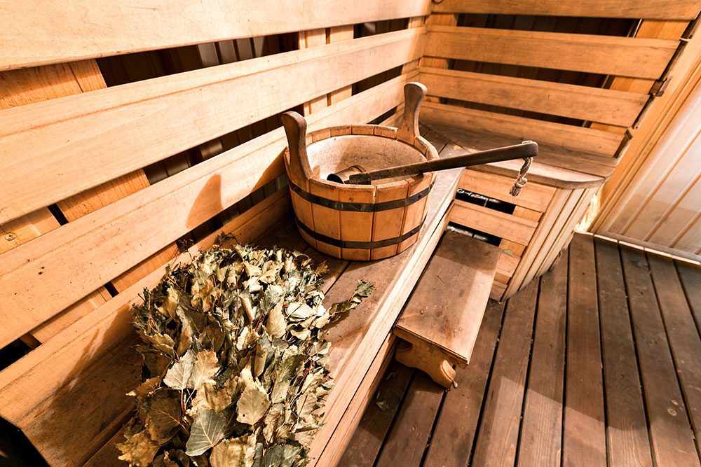 Hot wooden sauna room with ladle