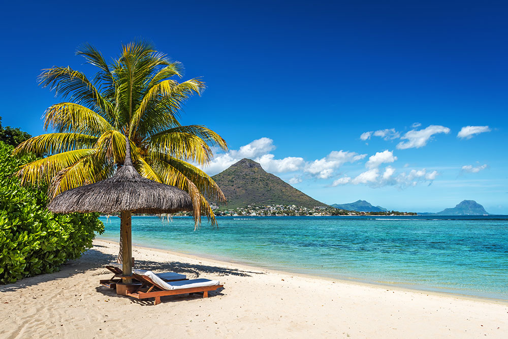 Loungers and umbrella on tropical beach in Mauritius