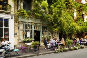 Famous style of life in Paris, France with Bistrots and people on terraces. Here, this is "The old Paris" traditional Bistrot on the Ile de la Cite in the spring time, near Notre Dame.
