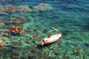 Enjoying the sun on a boat over the transparent green Mediterranean sea of Costa Brava