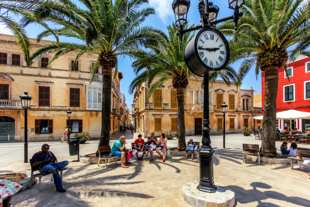 Tourists relaxing on Plaza Alfonzo III, at Ciutadella, on the island of Menorca, Spain
