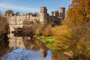 Warwick castle on the river Avon warm autumn day with fall colours