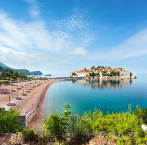 The view of Sveti Stefan sea islet with pink sandy Milocer Beach