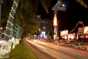 Enjoying the nightlife along the main coastal street (Av Costera Miguel Aleman) in Acapulco, Mexico. This street is lined with bars, restaurants, shops and hotels. the large tower with the Coke-cola neon signs a Bungy jump tower.