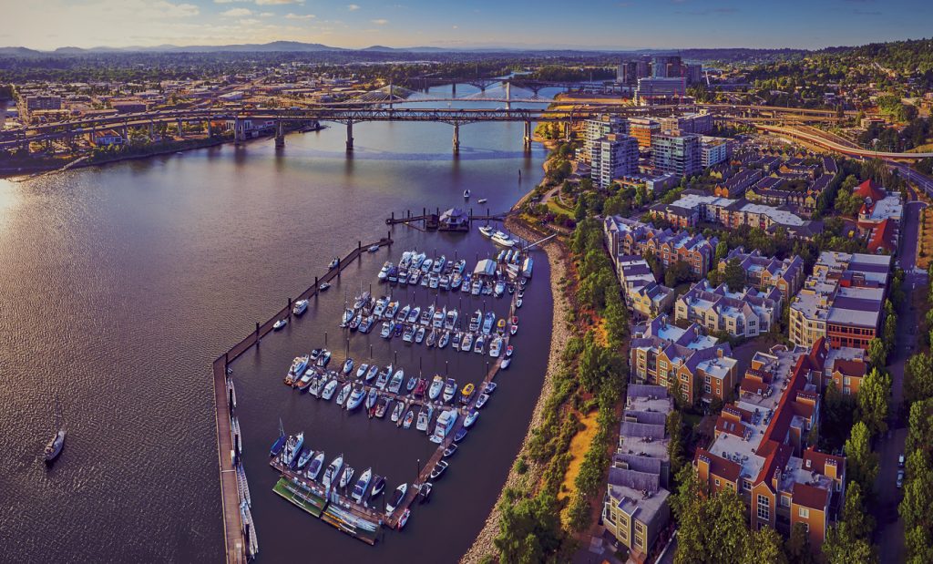 Aerial of Downtown Portland at Tom McCall Waterfront Park overlooking the Marina on early sunny morning with Tilikum Crossing Bridge in the distance