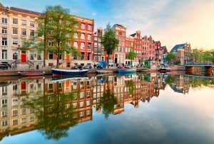 Beautiful Amsterdam sunset. Typical old dutch houses on the bridge and canals in spring, Netherlands