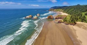 Aerial panorama shot at approximately 350 feet above Cannon Beach looking towards Ecola State Park on a sunny blue sky day on the Oregon Coast