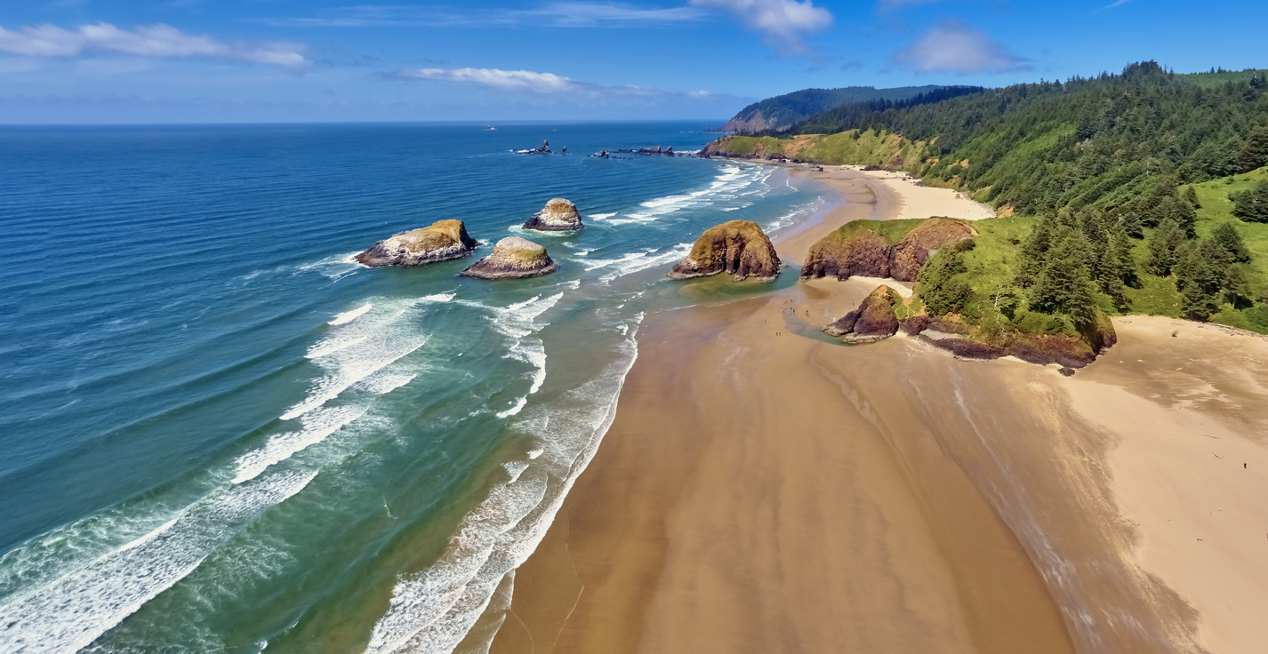 Aerial panorama shot at approximately 350 feet above Cannon Beach looking towards Ecola State Park on a sunny blue sky day on the Oregon Coast