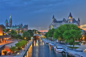 Ottawa at sunset with storm clouds advancing. Featuring Parliament Buildings, Rideau Canal a UNESCO world heritage site, Chateau Laurier Hotel, National Art Gallery and National Conference Centre. Boats docked along Rideau Canal.