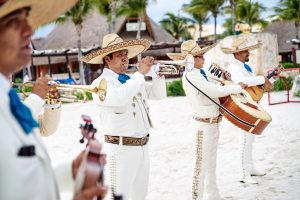 A group of traditional Mexican music band playing trumpet, classical guitar on the beach for beach wedding ceremony in Cancun, Yucatan, Mexico