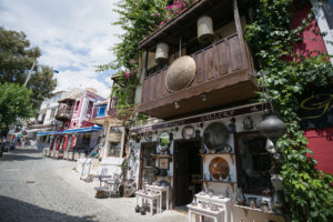 Antique shop decorated with metal trays, jugs, lanterns and other souvenirs on cobblestone paved narrow streets of Kalkan