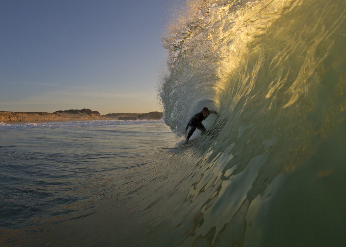 Surfer getting barreled in the afternoon light