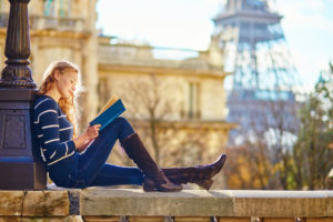 A beautiful young woman in Paris, reading a book