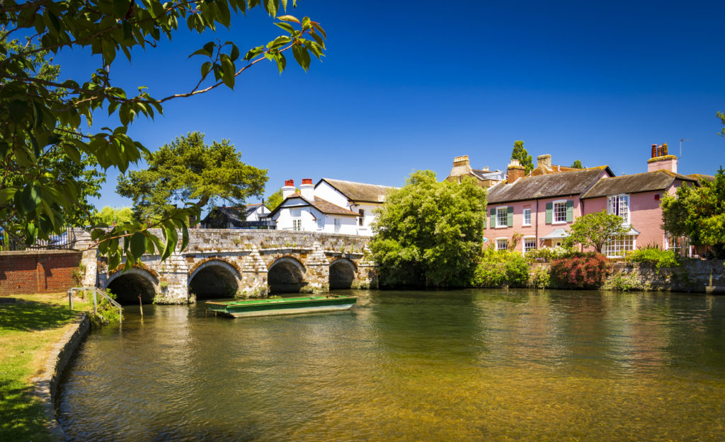 A stone bridge spans the River Avon Christchurch Dorset England on a hot summer day
