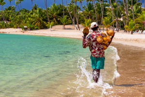 Caribbean coconut saler in walking in a tropical beach of Dominican Republic