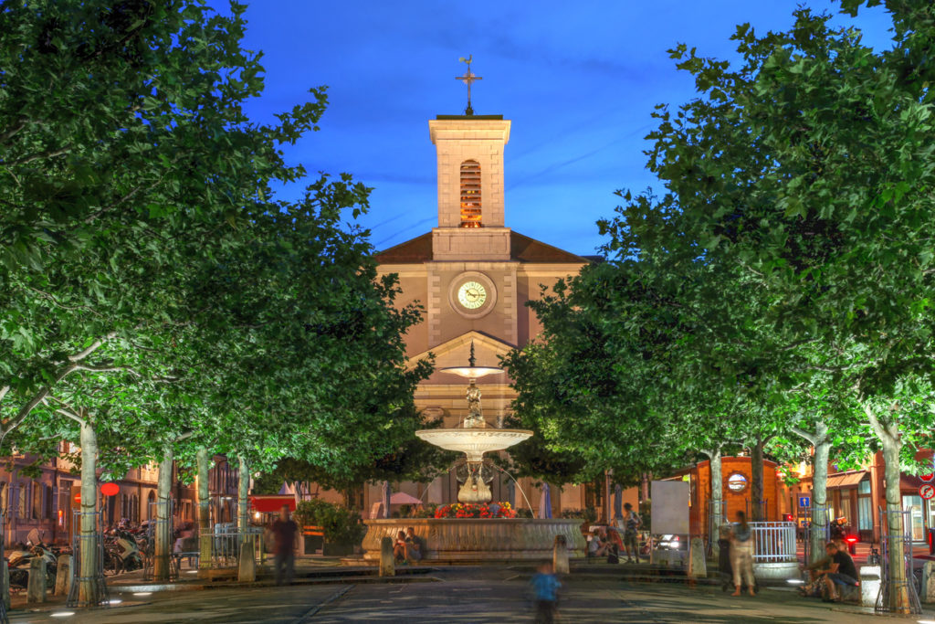 Night scene in Place de Marche, Carouge, Geneva, Switzerland with the Church of Sainte-Croix overlooking the square.