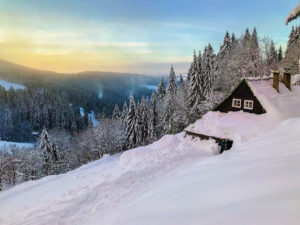 Czech mountains Krkonose landscape in winter in the early morning with lovely small wooden cottage