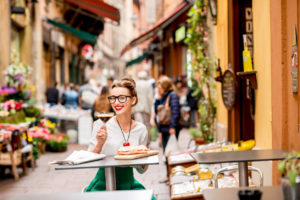 Sitting at the cafe with shakerato coffee and panini outdoor on the famous street with local food markets in Bologna city.