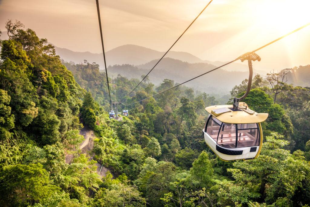 Aerial tramway moving up in tropical jungle mountains