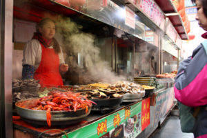 Vendors sell Chinese snacks on the 'food and drink' street of the shopping area Wangfujing