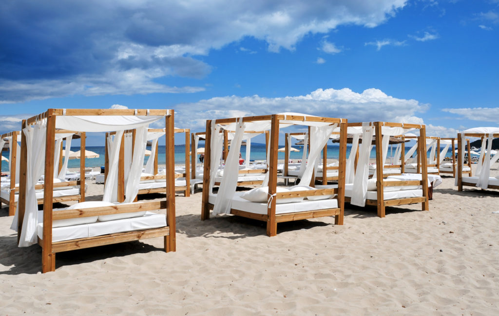 Beds and sunloungers in a beach club in a white sand beach in Ibiza, Spain