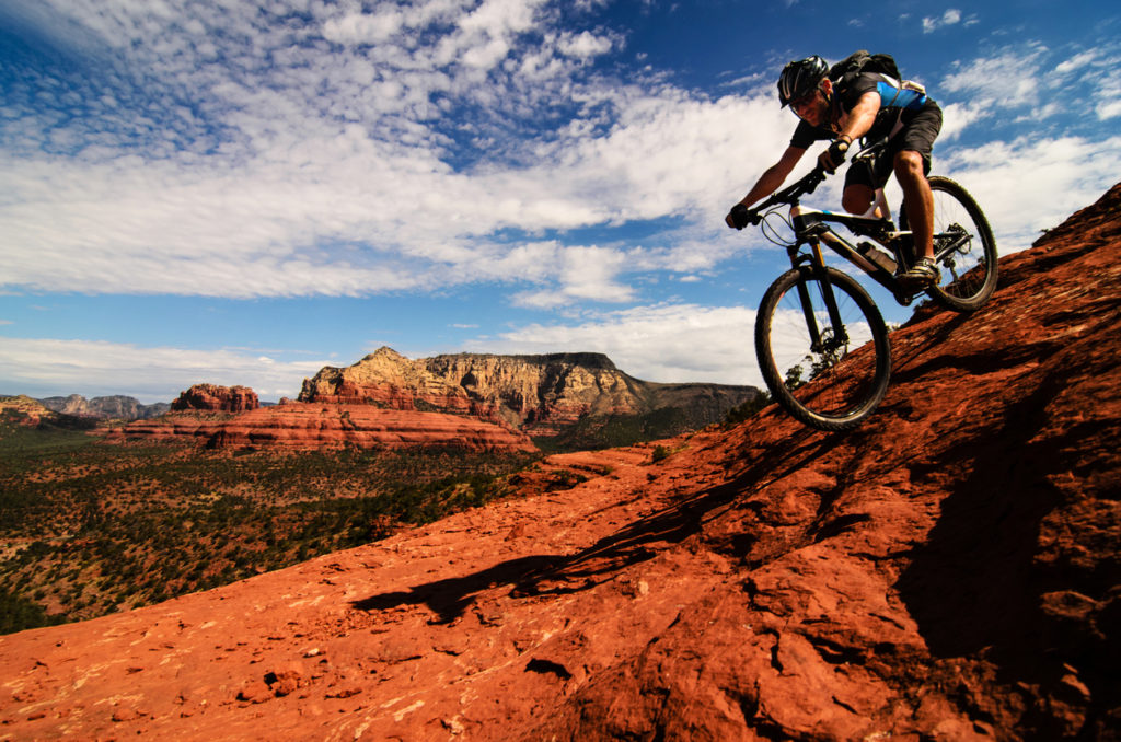 Mountain biker going downhill on slickrock in Sedona, Arizona