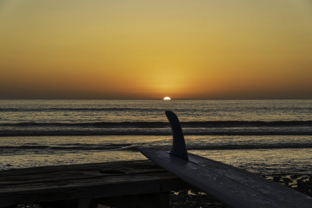 Classic Southern California surf scene at San Onofre beach with sunset