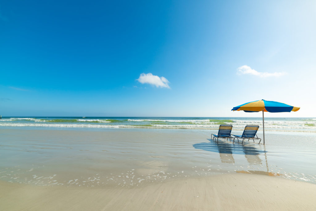 Parasol and beach chairs on the foreshore in Daytona Beach. Florida, USA