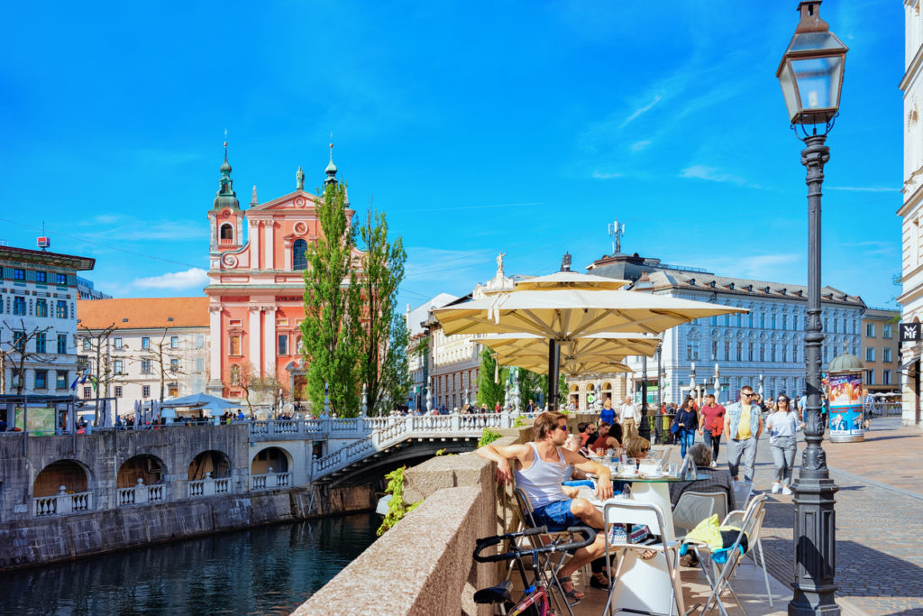 People at sidewalk cafe on Triple bridge Ljubljanica River Ljubljana