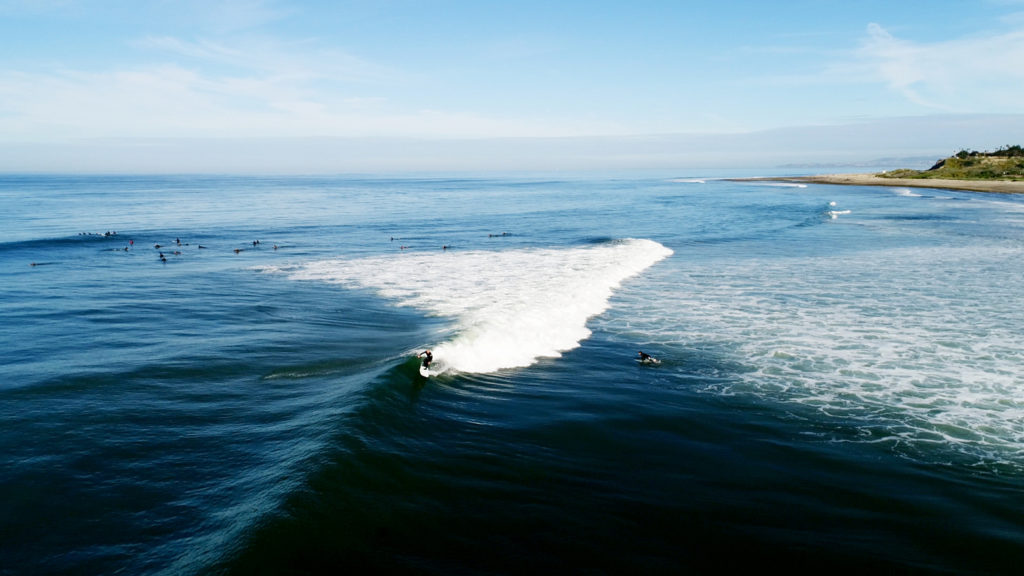 Surfer riding a wave at popular beach in Southern California orange county