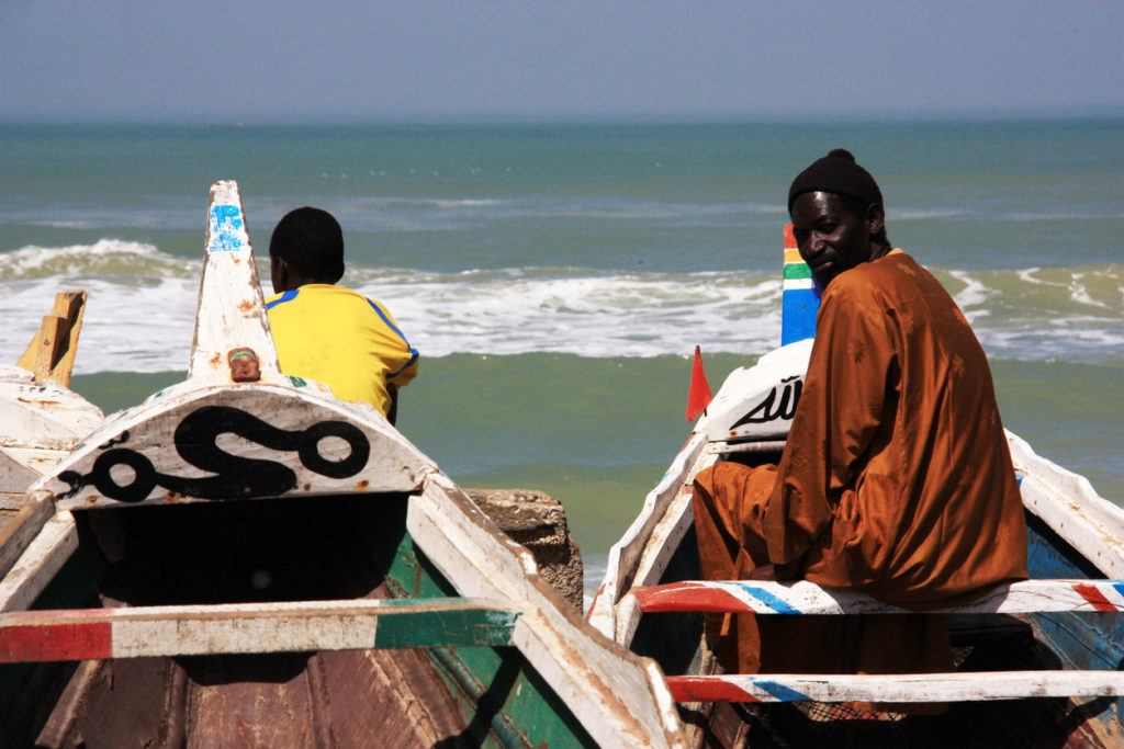 Fishermen sitting in their colorful painted pirogues in Saint-Louis-du-Sénégal
