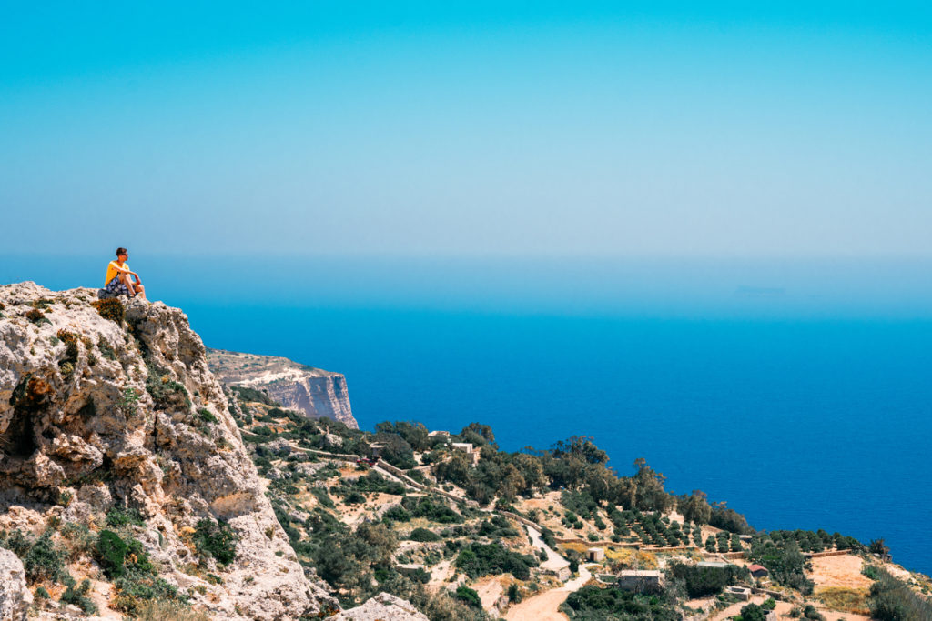 Young man sitting on the edge of the cliff