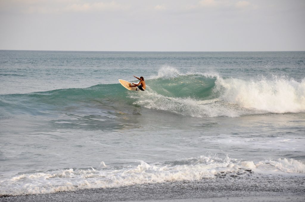 A surfer rides a wave at Jaco Beach