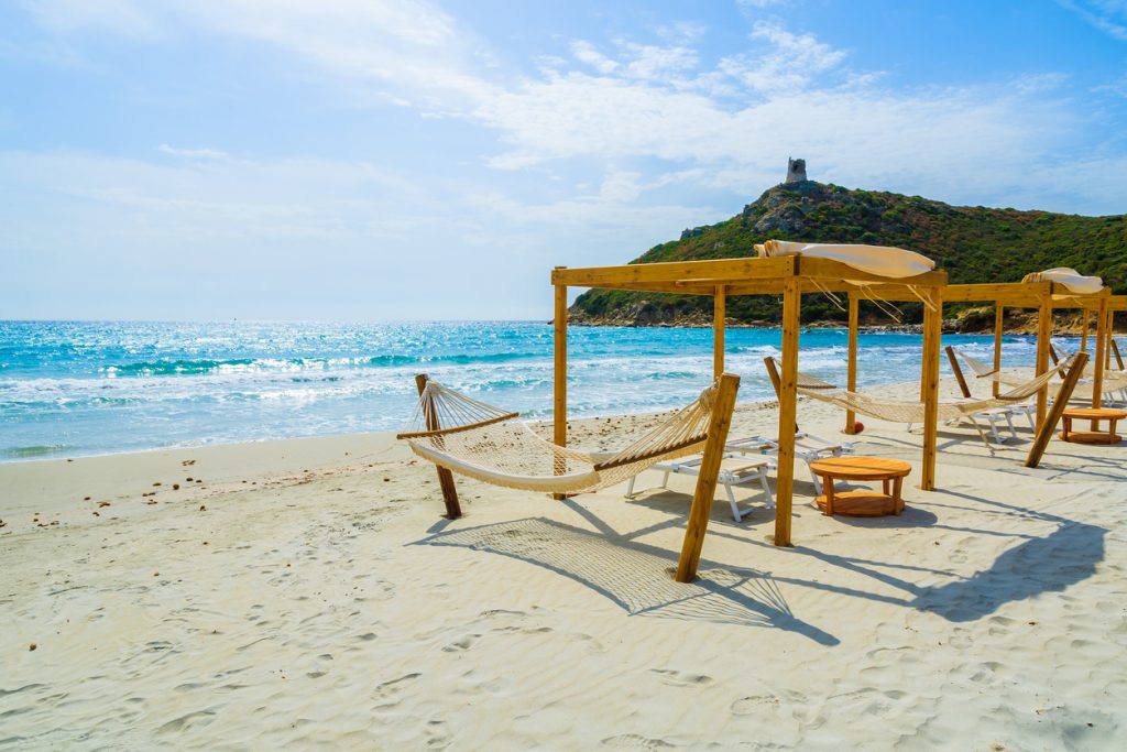 Hammocks and sun chairs on beach in Porto Giunco, Villasimius, Sardinia island, Italy