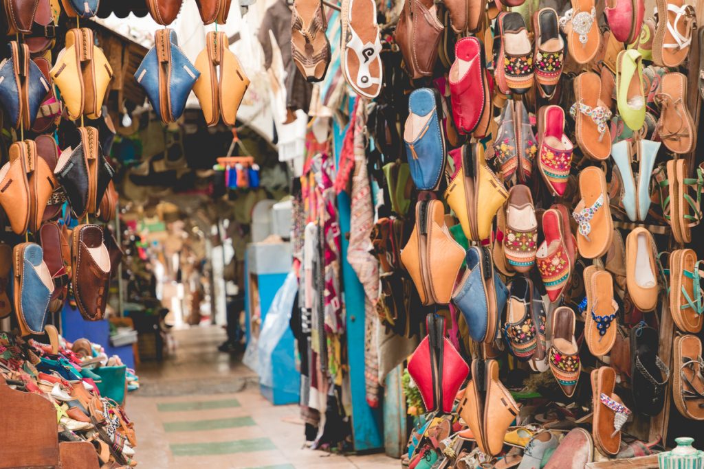 Moroccan leather goods bags and slippers at outdoor market in Marrakesh