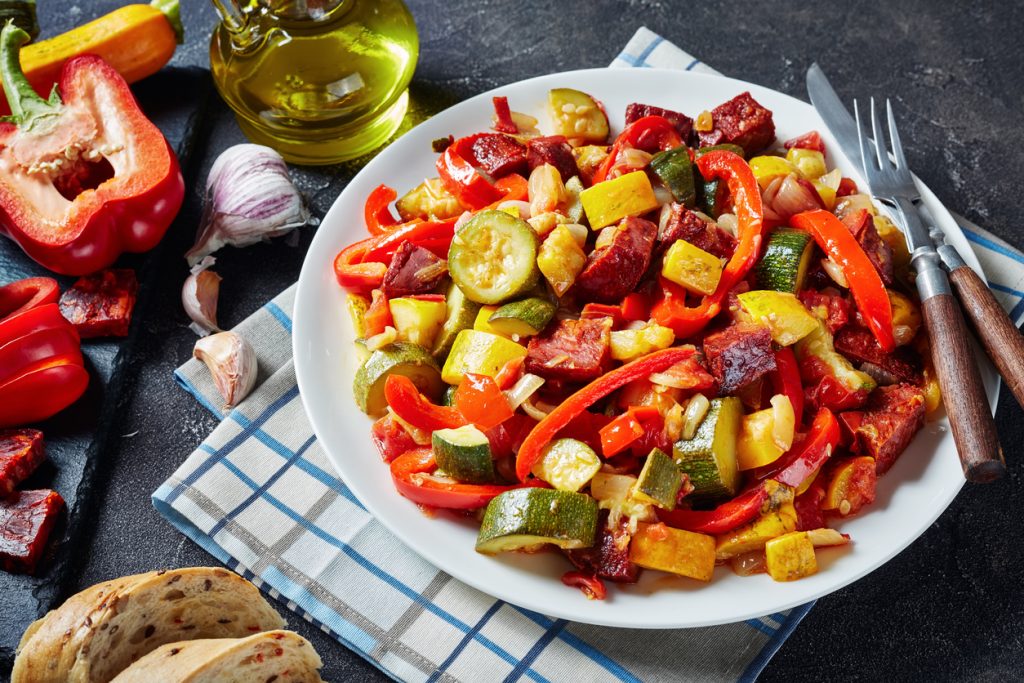 Pisto - Spanish vegetable stew with fried chorizo sausages served with sliced bread