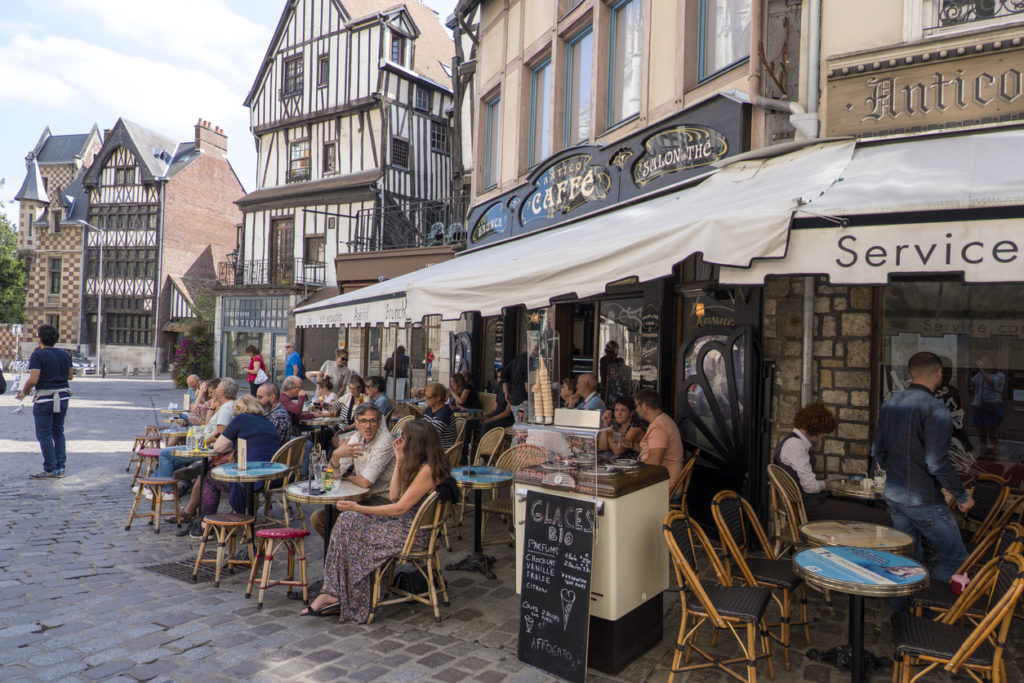 Residents of the city and tourists relax in a cafe on a street in the center of Rouen. Normandy,