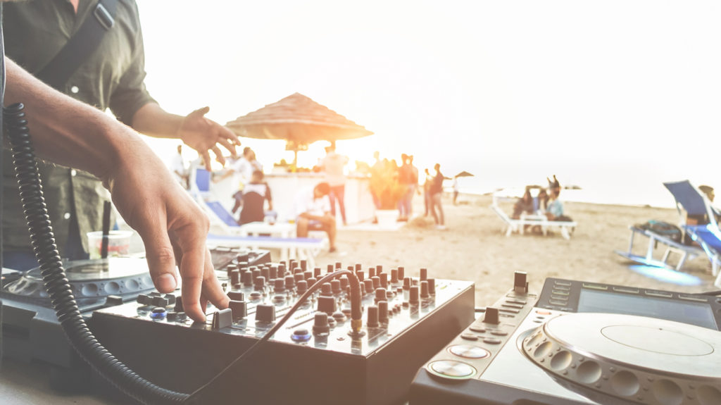 DJ mixing at sunset beach party