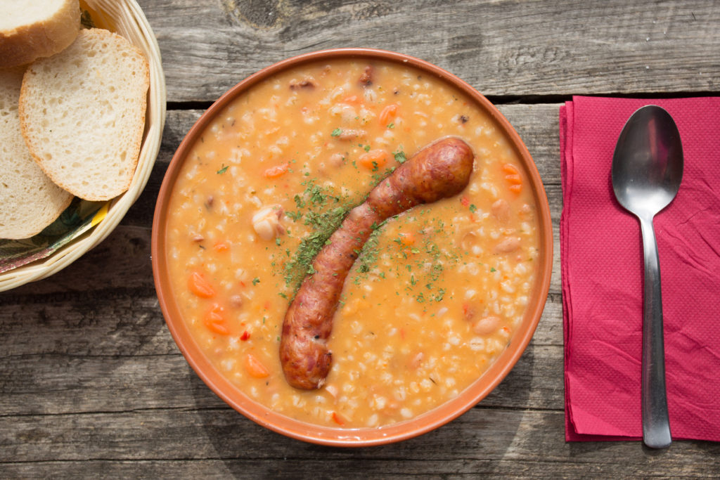 Barley soup with traditional krainer sausage in bowl