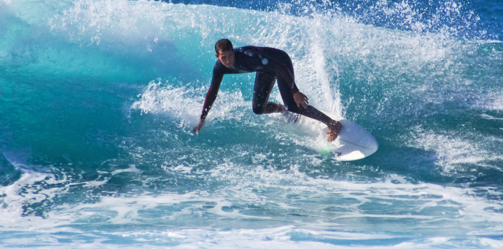 Surfer cuts a carve in Playa De Las Americas, Tenerife