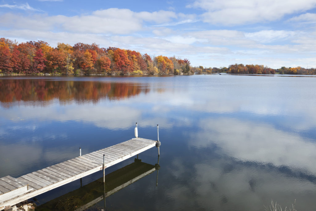 Calm Minnesota lake with dock and trees in Fall