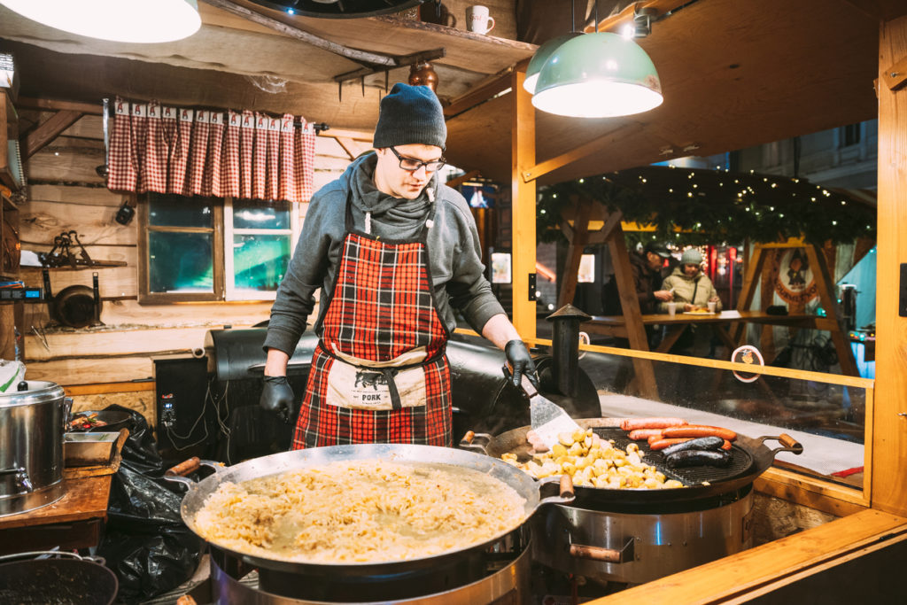 Man frying potatoes and sausages