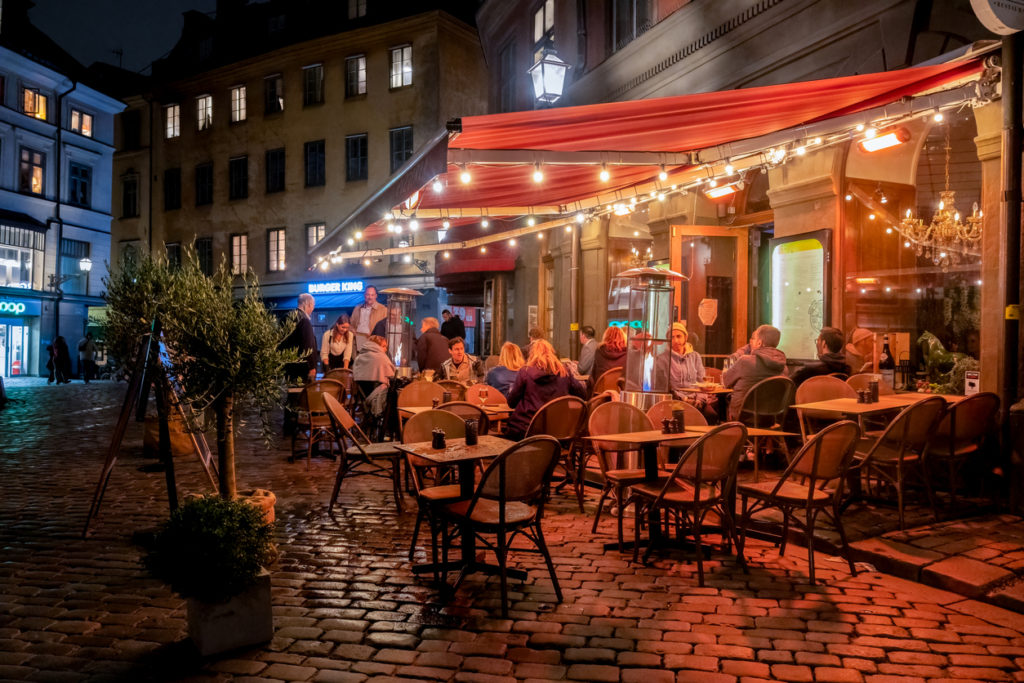Night scene with guests eating and drinking at a restaurant outdoors