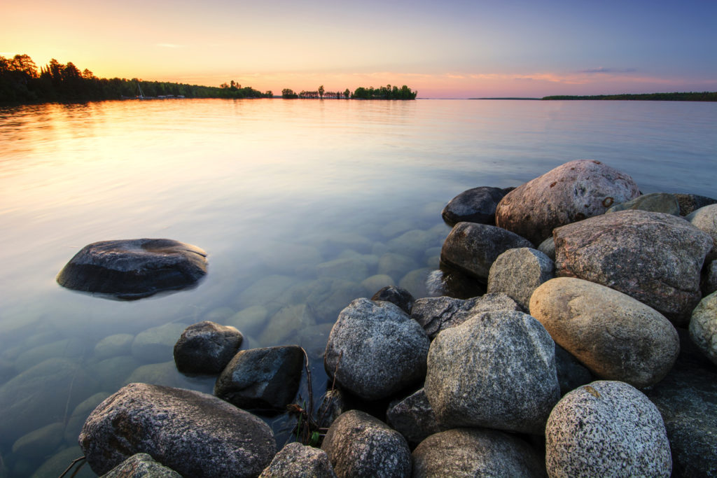 Large boulders on lake shore at sunset. Minnesota