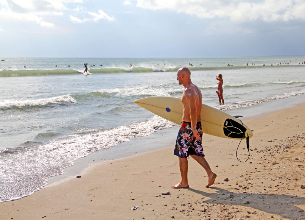 Surfer entering the water at Kuta Beach