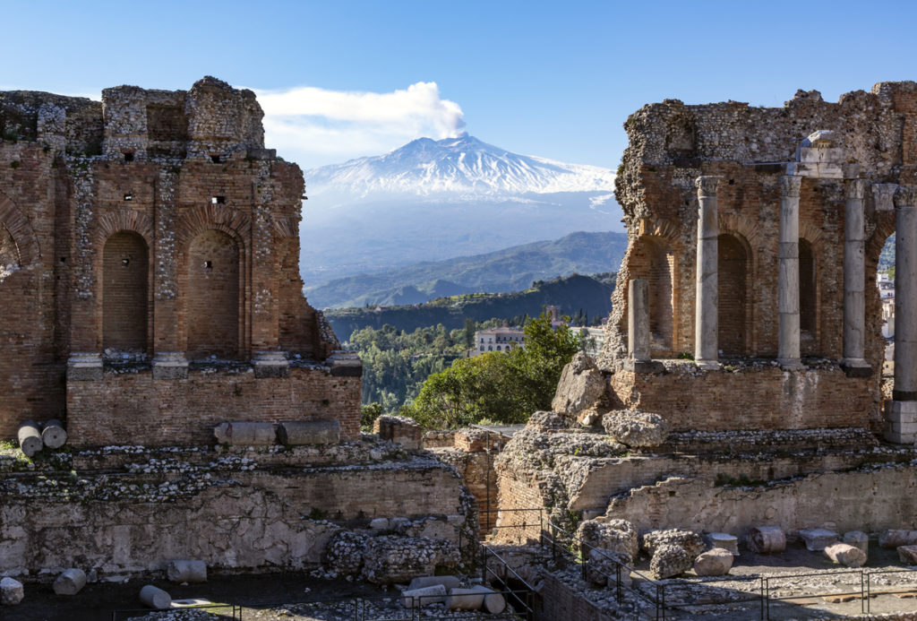 Ancient amphitheatre of Taormina, in the background is Volcano Etna, Sicily.