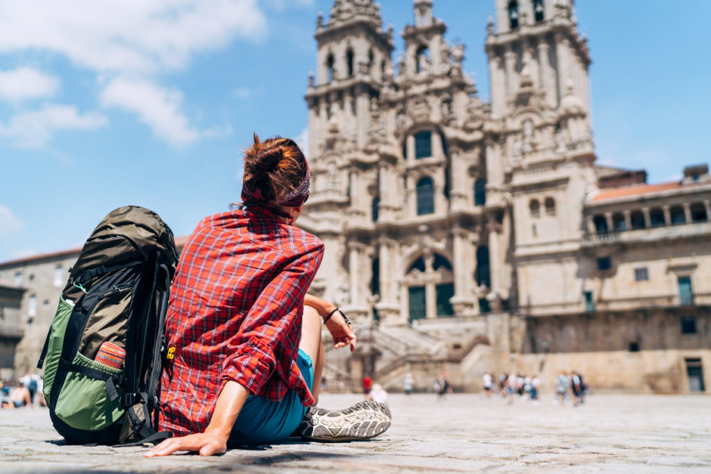 Woman backpacker siting on the Obdraderio square (plaza) in Santiago de Compostela, Chile.