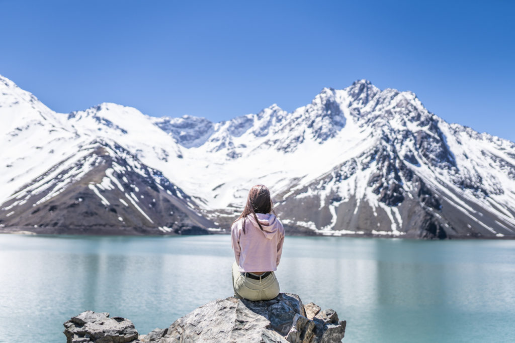 Women looking out to the Andes mountain range in Santiago de Chile over the Embalse del Yeso (Cast Lake).