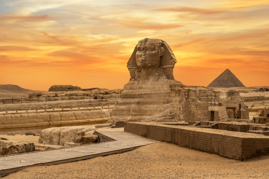 The Great Sphinx and the pyramids at sunset in Egypt.