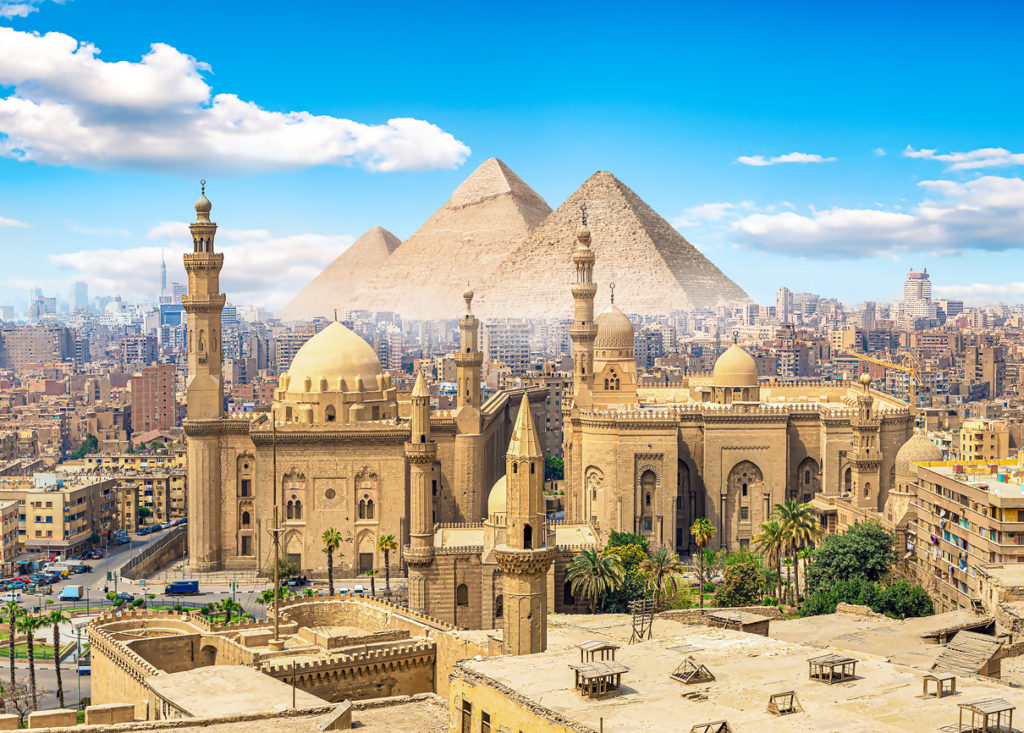 View of the Mosque Sultan Hassan in Cairo with the Pyramids of Giza in the background, Egypt.